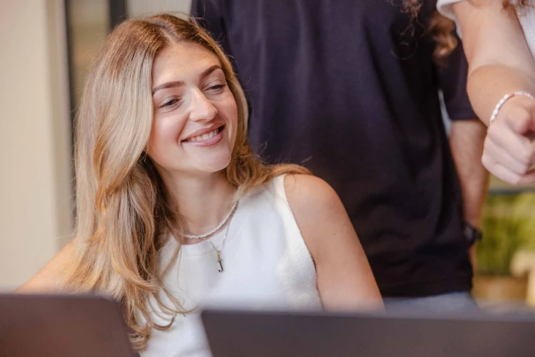 Woman in white top smiling.